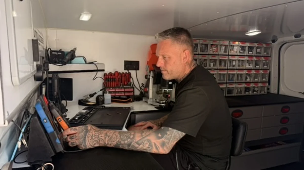 Kevin from Auto Access programming a car key with diagnostic equipment inside his mobile locksmith van
